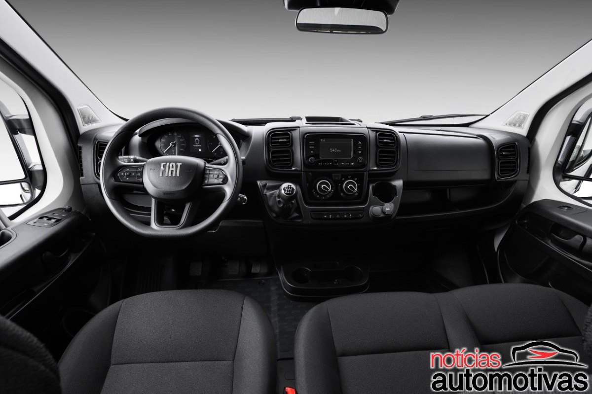 Interior dianteiro da Fiat Ducato, com volante Fiat, painel, central multimídia, câmbio manual e dois bancos.