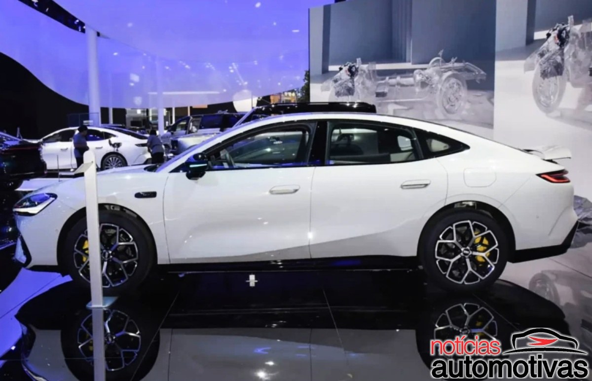 Geely Galaxy TT branco visto de lado em um salão de exposição.