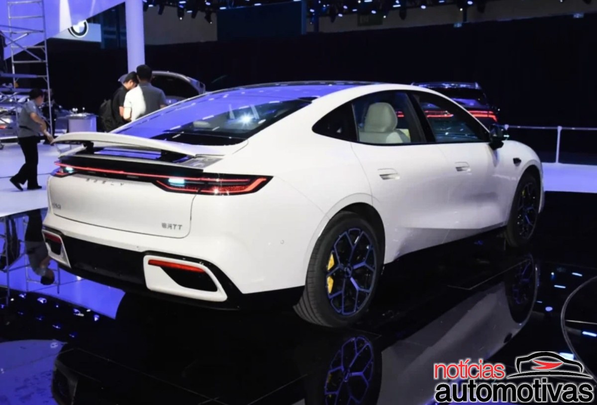 Geely Galaxy TT branco visto pela traseira em um salão de exposição.
