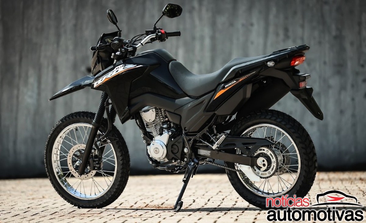 Honda NXR160 Bros preta vista de lado, apoiada no cavalete diante de uma parede cinza.