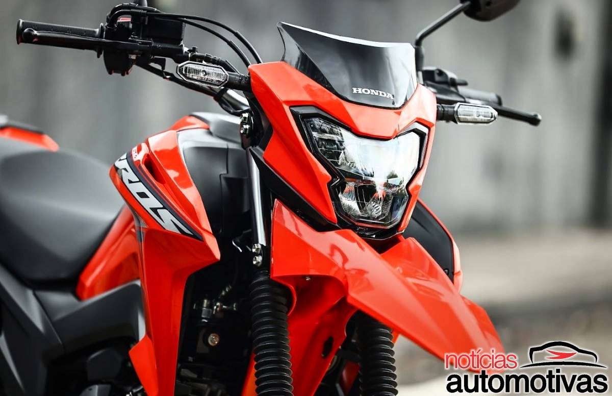 Parte dianteira de uma motocicleta Honda vermelha, com farol, carenagem e indicadores de direção visíveis.