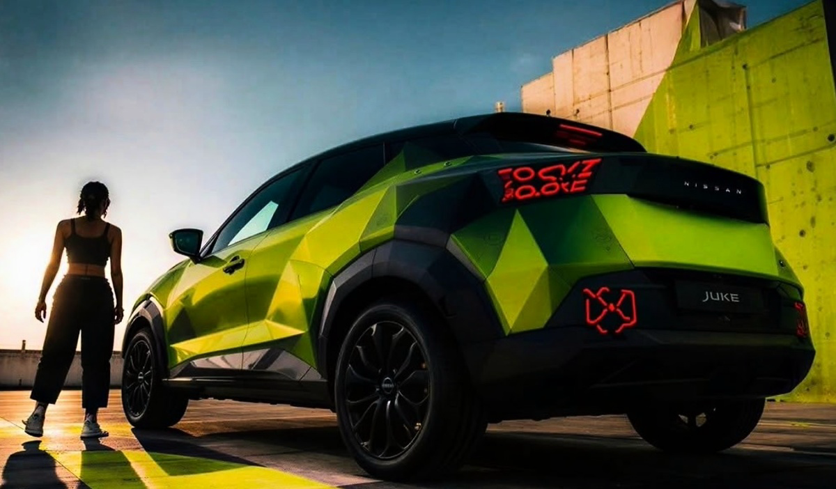 Nissan Juke verde e preto visto de trás, com uma mulher ao lado, em área externa junto a uma parede colorida.