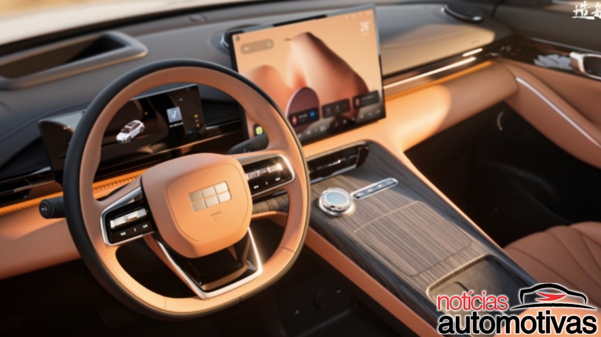 Interior de SUV com volante dianteiro, painel digital, tela central e acabamento marrom com detalhes metálicos.