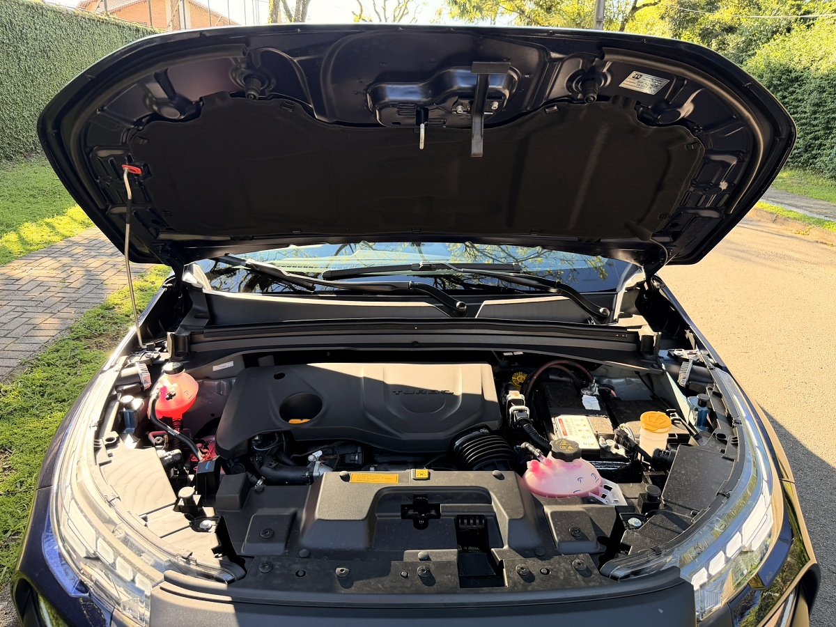 Compartimento do motor da Fiat Toro com o capô aberto, mostrando componentes, bateria e reservatórios.