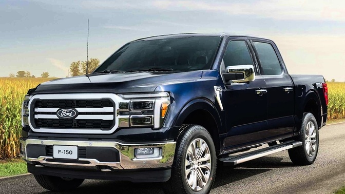 Ford F-150 azul-escura estacionada em uma estrada, com vegetação ao fundo.