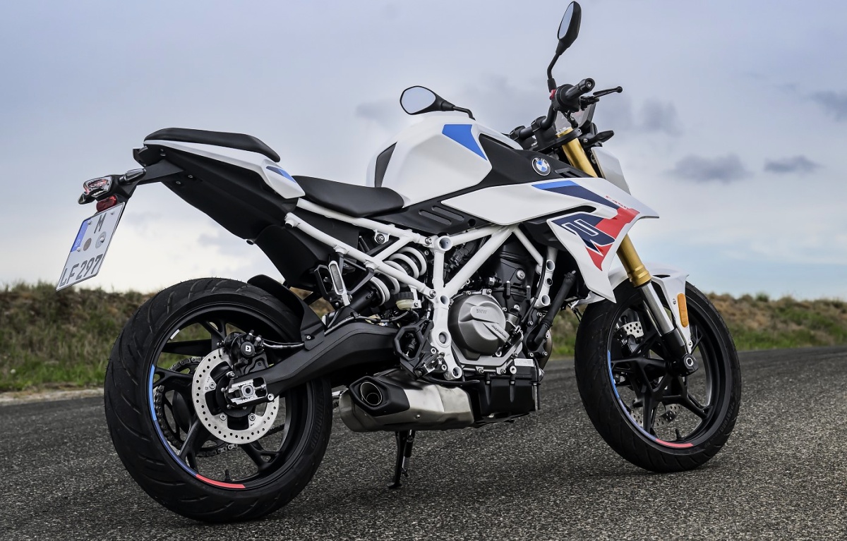 BMW F 450 R branca com detalhes azuis e vermelhos vista pelo lado esquerdo, parada em uma estrada.