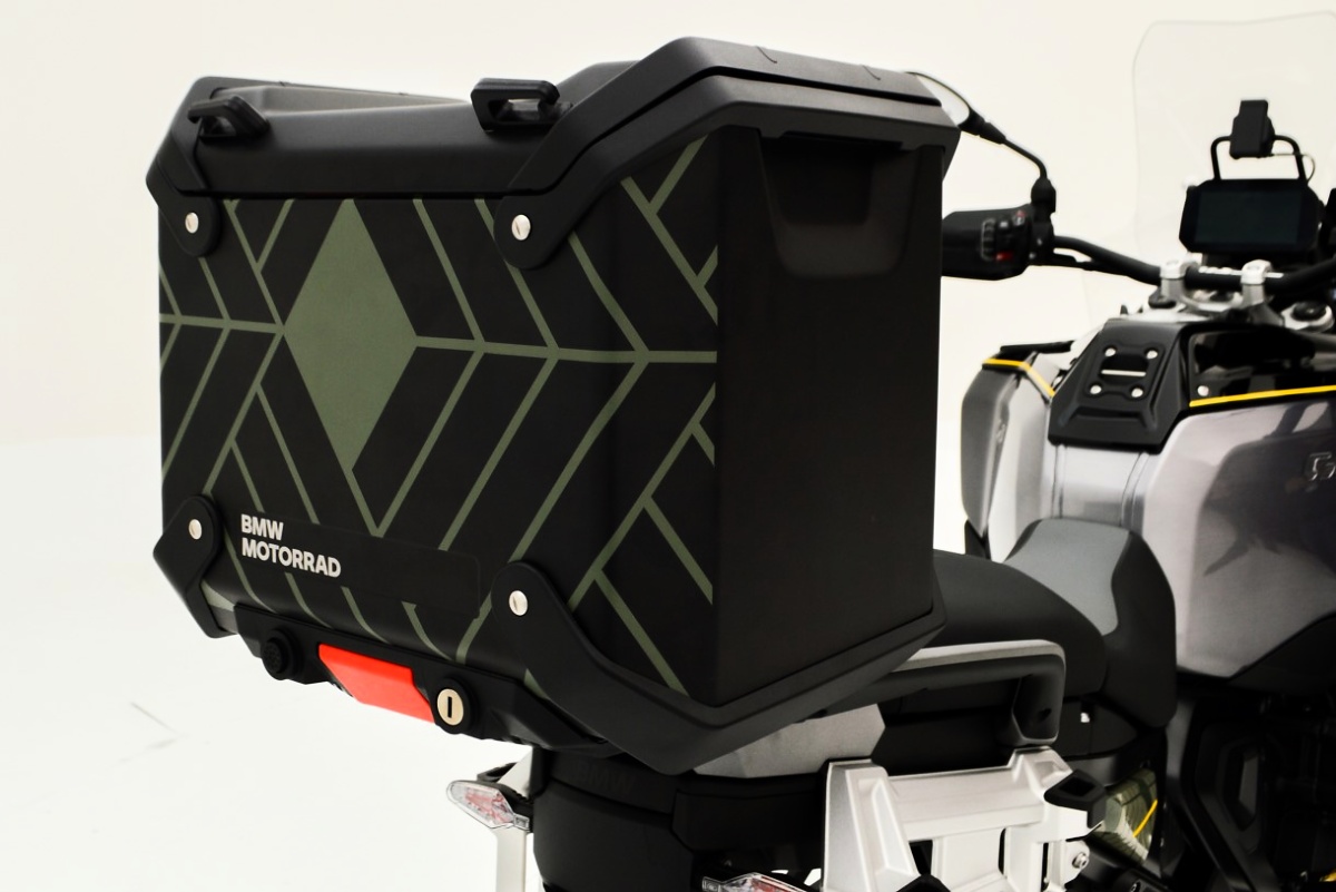 Baú traseiro preto com grafismos verdes e inscrição BMW Motorrad, instalado na parte de trás de uma motocicleta.