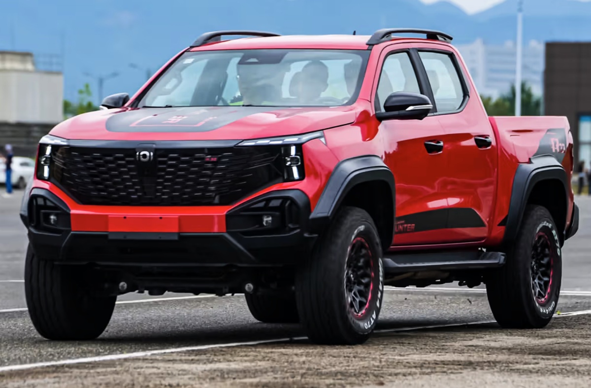 Picape vermelha Changan Hunter K70 vista de frente e de lado em uma área pavimentada.