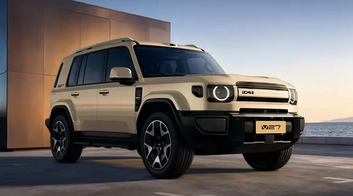 SUV bege visto de frente e de lado, com faróis circulares, grade estreita e para-choques pretos.