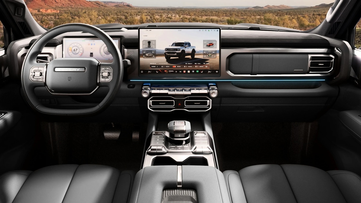 Interior de picape com volante, painel digital, tela central e console; o volante traz o logotipo CHERY.