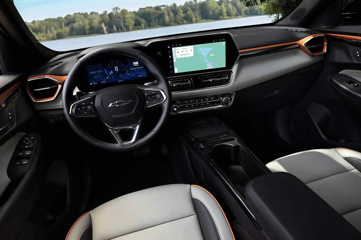 Painel interno de um Chevrolet Trailblazer Z71, com volante, telas, detalhes alaranjados e bancos claros.