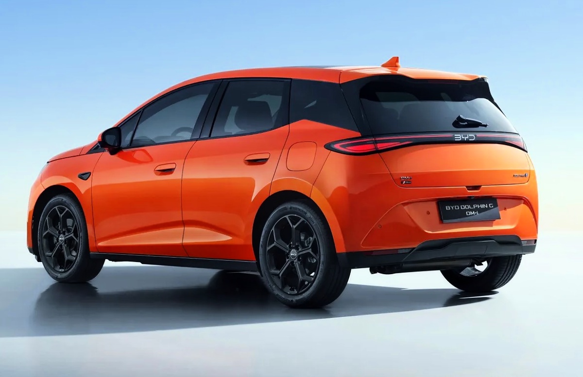 BYD Dolphin G laranja visto pela traseira e pela lateral, em fundo claro.