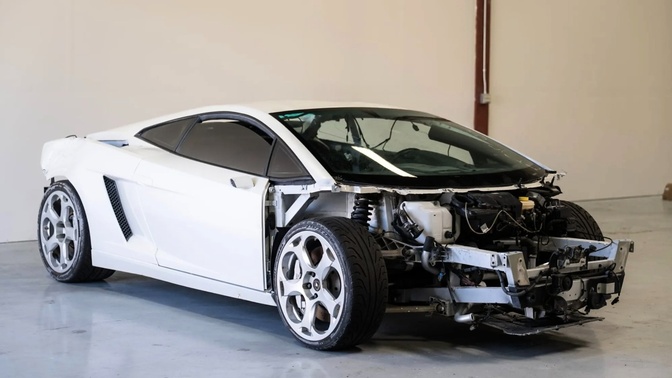 Lamborghini Gallardo branco em ambiente interno, sem a dianteira e com componentes mecânicos expostos.