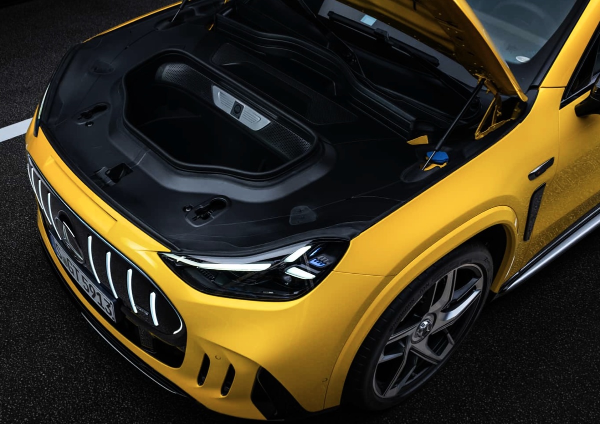 Compartimento dianteiro aberto de um Mercedes-AMG GT SUV amarelo, visto de cima, com acabamento interno preto.