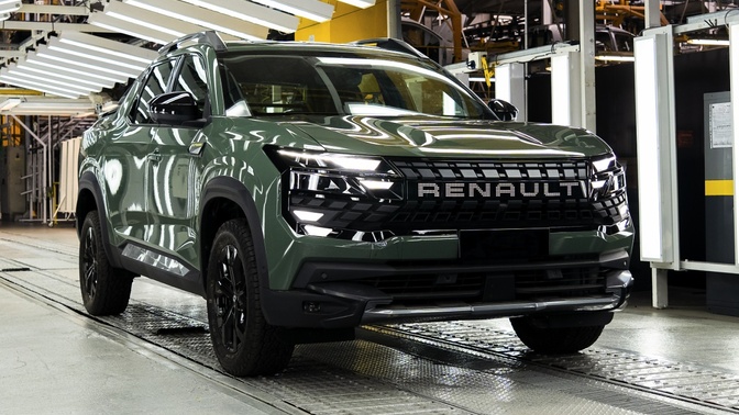 Picape Renault Niagara verde-escura em uma linha de montagem, vista de frente e de lado.