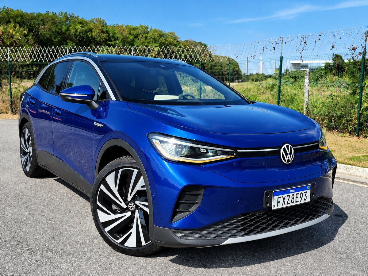 Volkswagen ID.4 azul visto de frente e de lado, estacionado junto a uma cerca; há uma marca d’água no canto inferior direito.